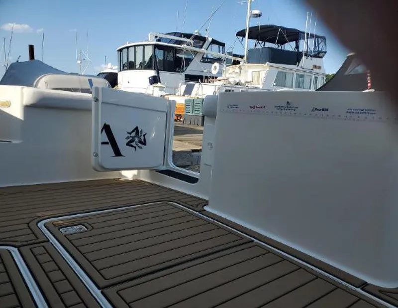 Slide: The Image of 2005 Silverton 34 Convertible boat deck with teak flooring and marina background. - 4