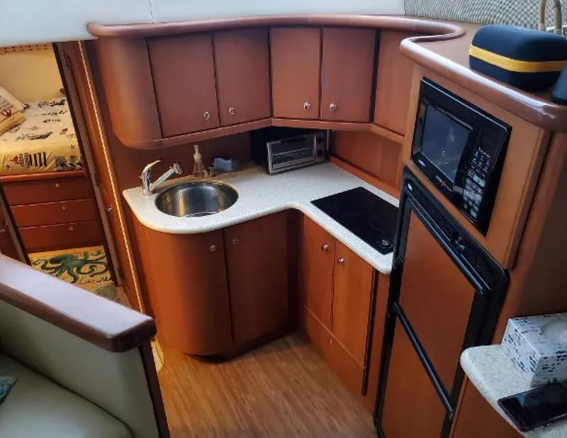 Slide: The Image of 2005 Silverton 34 Convertible yacht kitchen with wood cabinets, sink, stove, and microwave. - 8