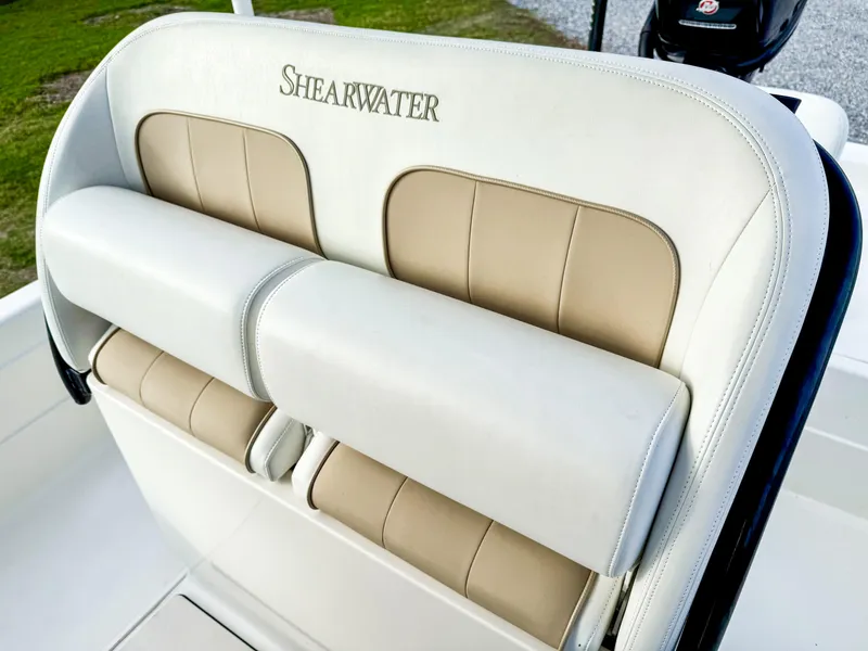 Slide: The Image of ShearWater 25LTZ 2016 boat seat with beige and white upholstery. - 10