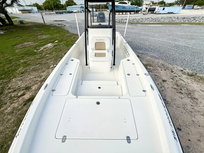 Slide: The Image of 2016 ShearWater 25LTZ boat, white deck, spacious seating, parked outdoors. - 7