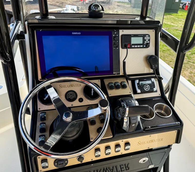 Slide: The Image of Control panel of 2016 ShearWater 25LTZ boat with steering wheel and navigation equipment. - 8
