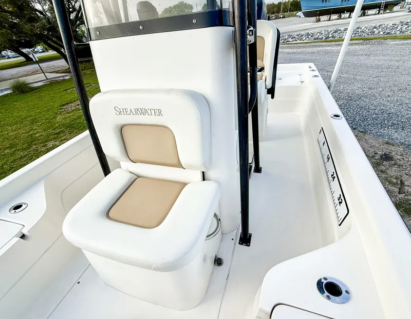 Slide: The Image of 2016 ShearWater 25LTZ boat interior with cushioned seating and console. - 9