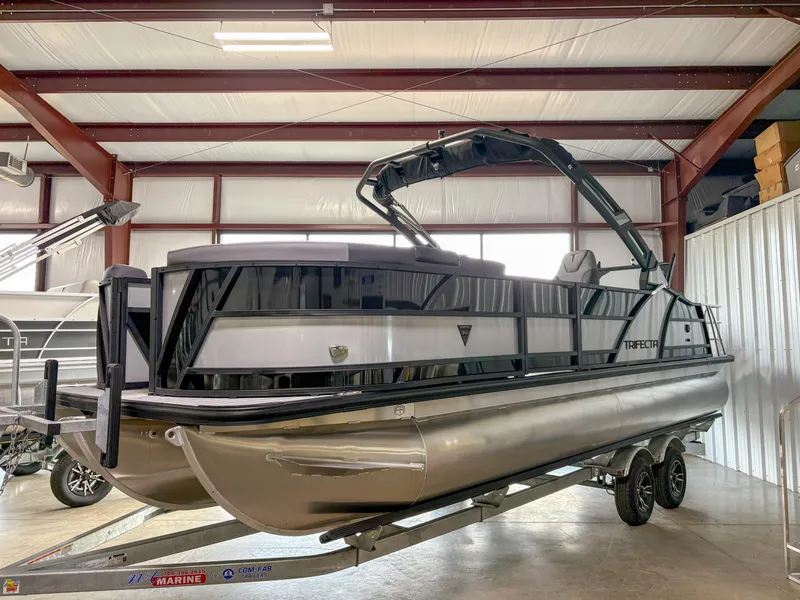 Slide: The Image of 2025 Trifecta 23 UL SS Arch pontoon boat on trailer in indoor storage. - 1