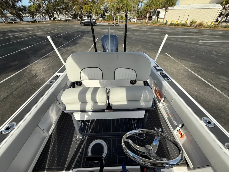 Slide: The Image of 2021 Sea Fox 248 Commander boat interior with dual seats and steering wheel in a parking lot. - 21