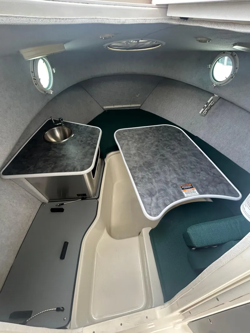 Slide: The Image of 2007 Trophy 2302 Walkaround cabin interior with table and sink. - 12