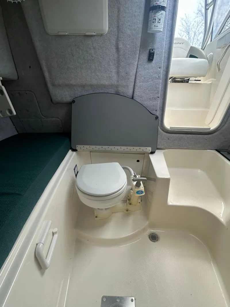 Slide: The Image of 2007 Trophy 2302 Walkaround boat interior with compact toilet and seating area. - 13