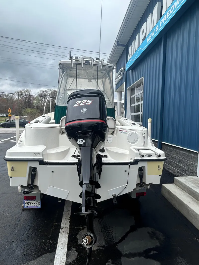 Slide: The Image of 2007 Trophy 2302 Walkaround boat with 225 HP engine, parked outside a blue building. - 2
