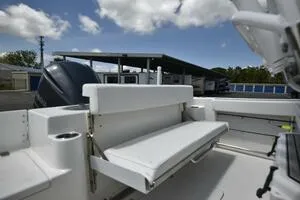 Slide: The Image of 2023 Sea Pro 239 Deep V CC boat interior with seating and storage under a blue sky. - 32