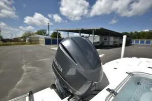 Slide: The Image of 2023 Sea Pro 239 Deep V CC boat on trailer, parked in driveway under clear blue sky. - 5