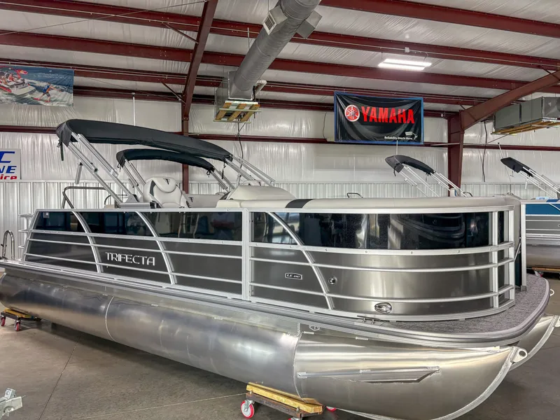 The Image of 2025 Trifecta 22 UL LE T pontoon boat in a showroom with Yamaha banner. - 1
