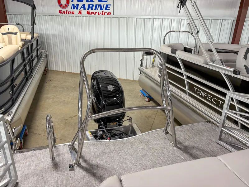 Slide: The Image of 2025 Trifecta 22 UL LE T pontoon boat in showroom, featuring sleek design and powerful engine. - 16