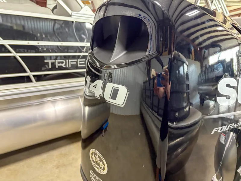 Slide: The Image of Outboard motor on a 2025 Trifecta 22 UL LE T pontoon boat in a showroom. - 5
