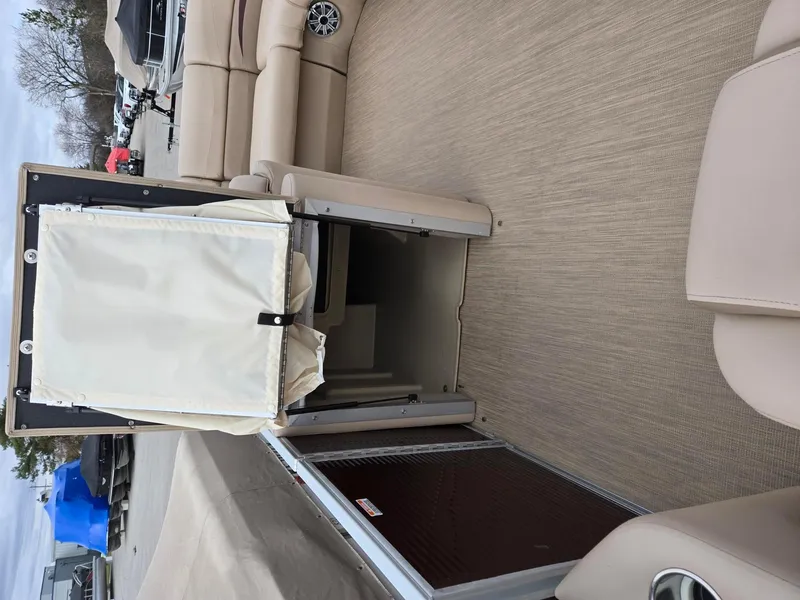 Slide: The Image of 2017 Bennington 22GSR pontoon boat interior with beige seating and storage compartment. - 16