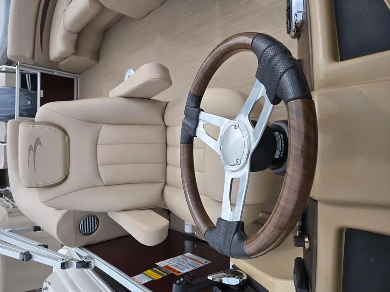 Slide: The Image of Steering wheel and seat of 2017 Bennington 22GSR boat, featuring beige upholstery. - 20