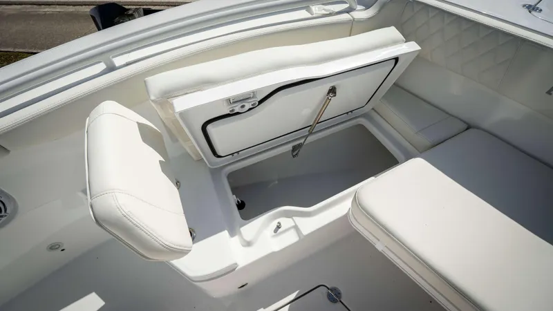 Slide: The Image of 2025 Everglades 315 CC boat interior with open storage compartment and white seating. - 10