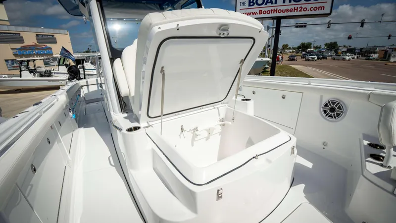 Slide: The Image of 2025 Everglades 315 CC boat with open storage compartment at a dealership. - 13