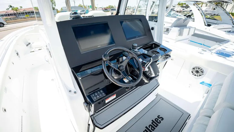 Slide: The Image of 2025 Everglades 315 CC boat cockpit with modern steering and dual screens. - 24