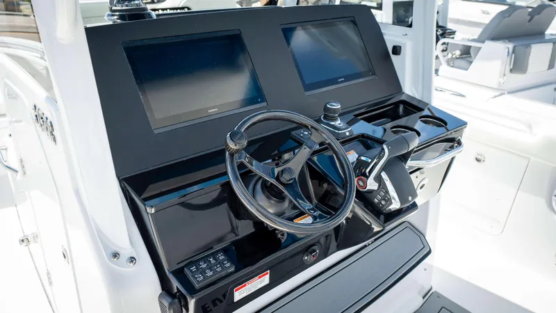 Slide: The Image of 2025 Everglades 315 CC boat helm with dual screens and modern controls. - 25