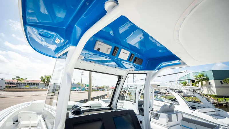 Slide: The Image of 2025 Everglades 315 CC boat interior with blue overhead console and modern navigation equipment. - 26
