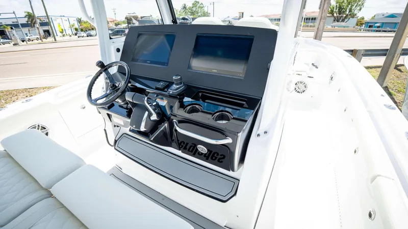 Slide: The Image of 2025 Everglades 315 CC boat cockpit with dual screens and steering wheel. - 29