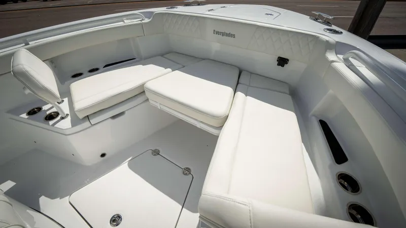 Slide: The Image of 2025 Everglades 315 CC boat interior with white cushioned seating. - 6