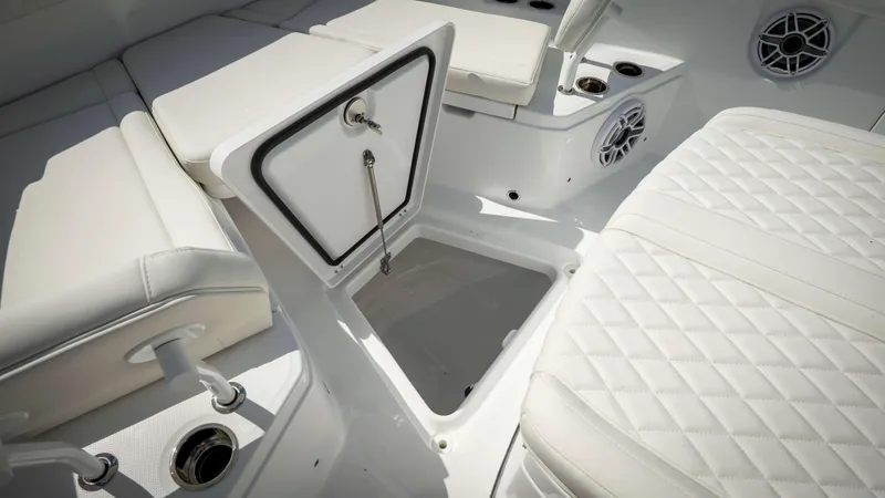 Slide: The Image of 2025 Everglades 315 CC boat interior with white cushioned seating and storage compartment. - 7