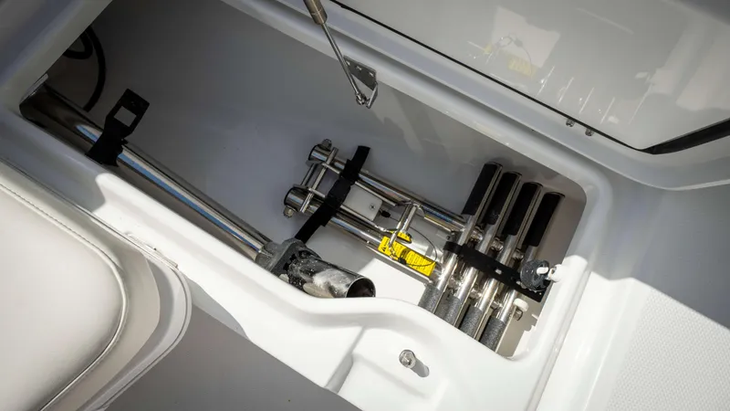 Slide: The Image of Storage compartment in 2025 Everglades 315 CC boat, featuring secured metal rods. - 9