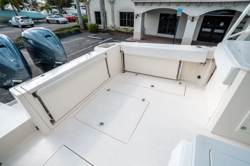 Slide: The Image of 2020 Cobia 330 DC boat deck with Yamaha V8 engines in a marina setting. - 12