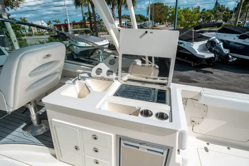 Slide: The Image of 2020 Cobia 330 DC boat interior with sink, grill, and storage compartments. - 22