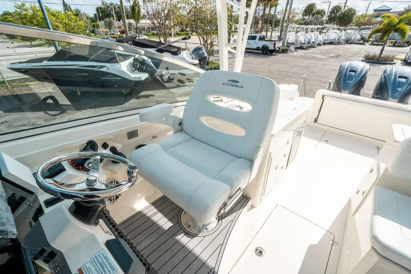 Slide: The Image of 2020 Cobia 330 DC boat interior with steering wheel and captain's chair. - 28