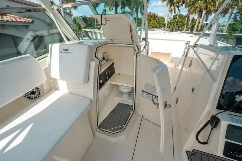 Slide: The Image of 2020 Cobia 330 DC boat interior with open cabin door, showcasing seating and amenities. - 31