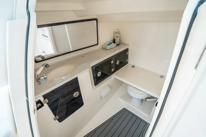 Slide: The Image of 2020 Cobia 330 DC boat bathroom interior with sink, mirror, and toilet. - 32