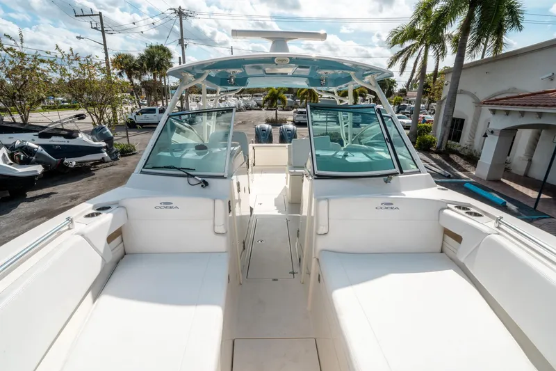 Slide: The Image of 2020 Cobia 330 DC boat interior with seating, docked under sunny skies. - 39