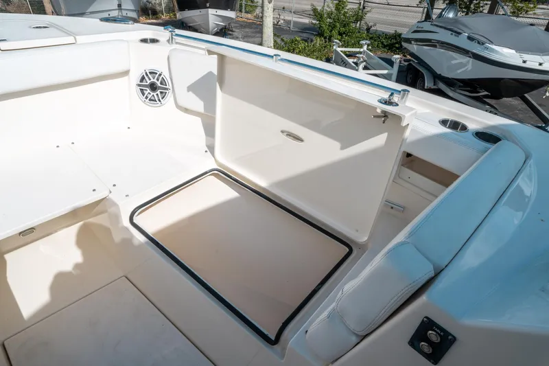 Slide: The Image of 2020 Cobia 330 DC boat interior with open storage compartment and seating area. - 42