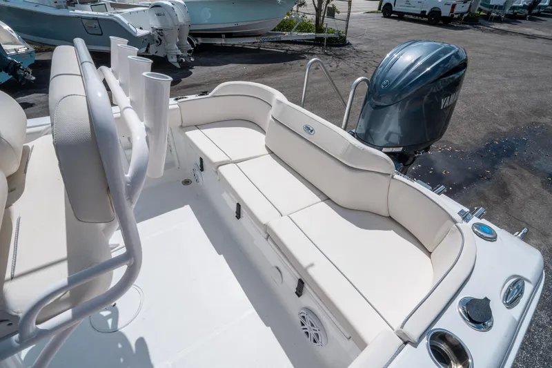 Slide: The Image of 2025 Sea Hunt Ultra 219 boat interior with Yamaha engine, featuring white seating and rod holders. - 11
