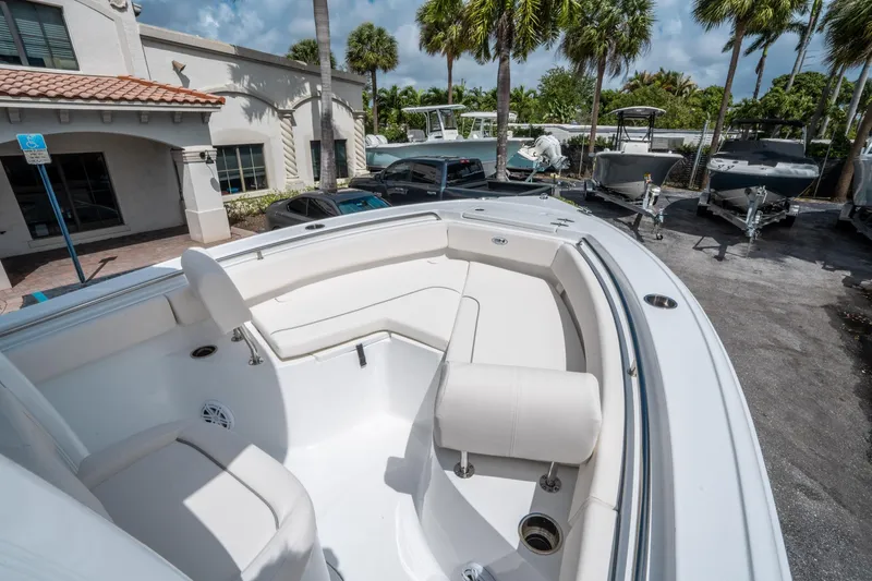 Slide: The Image of 2025 Sea Hunt Ultra 219 boat with spacious seating, parked near palm trees. - 22