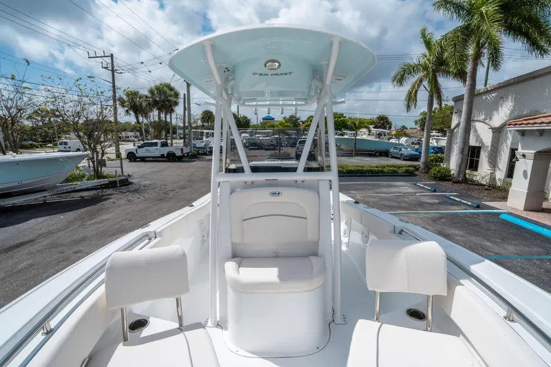 Slide: The Image of 2025 Sea Hunt Ultra 219 boat with seating, parked outdoors under a cloudy sky. - 23