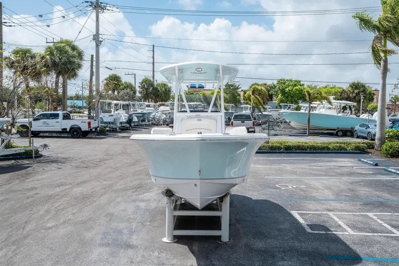 Slide: The Image of 2025 Sea Hunt Ultra 219 boat displayed in a parking lot under a clear sky. - 7