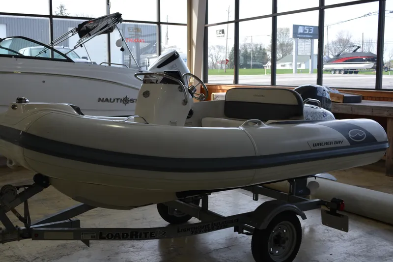 Slide: The Image of 2016 Walker Bay Generation 340 DLX boat on trailer in showroom. - 2