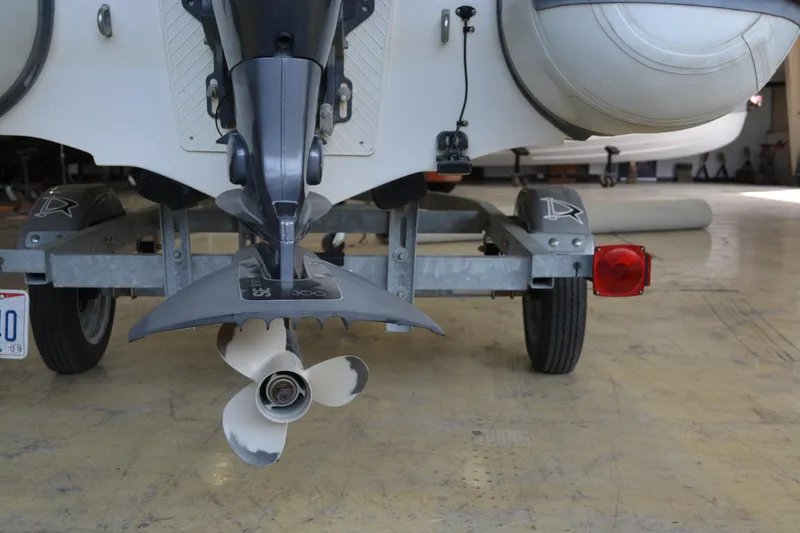 Slide: The Image of Walker Bay Generation 340 DLX 2016 boat on trailer, showing propeller and rear view. - 5