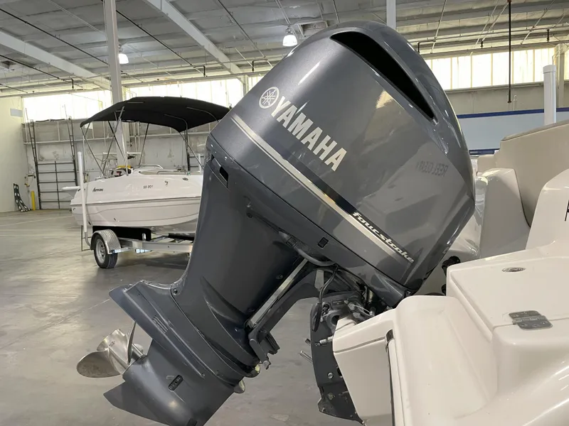 Slide: The Image of 2023 Key West 239 FS boat with Yamaha outboard motor in a warehouse setting. - 13