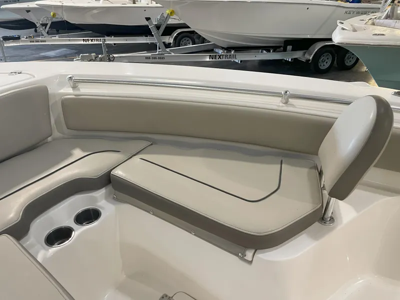 Slide: The Image of 2023 Key West 239 FS boat interior with cushioned seating and cup holders. - 21