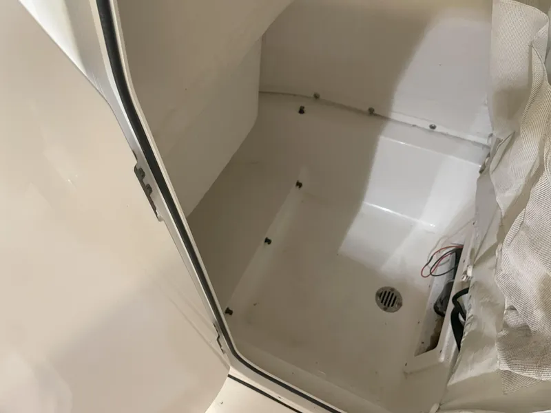 Slide: The Image of 2023 Key West 239 FS boat interior compartment with drain and wiring. - 28
