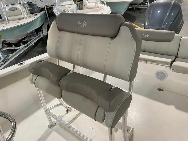 Slide: The Image of 2023 Key West 239 FS boat with cushioned seating and sleek design in a showroom. - 31
