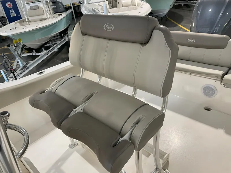 Slide: The Image of 2023 Key West 239 FS boat seating, featuring cushioned dual seats in a showroom setting. - 32