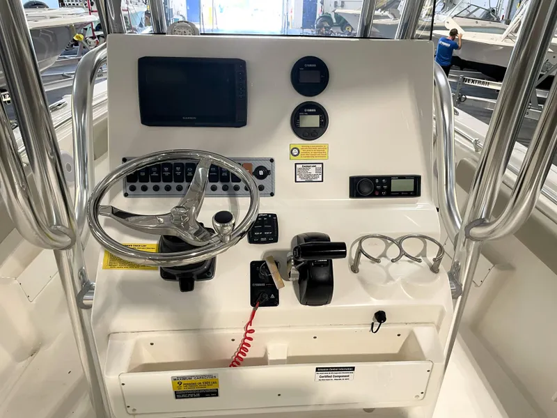 Slide: The Image of 2023 Key West 239 FS boat console with steering wheel, gauges, and controls. - 33