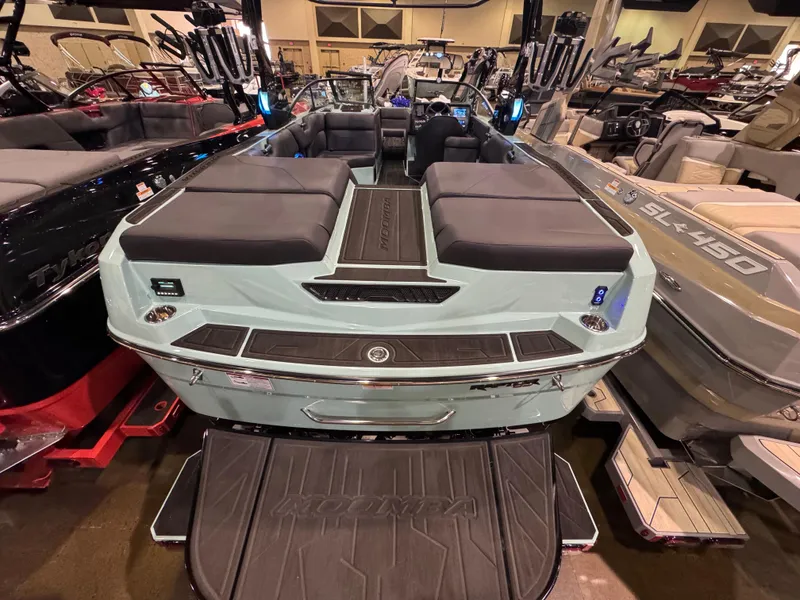 Slide: The Image of 2025 Moomba Max boat with sleek design and spacious seating at a showroom display. - 14