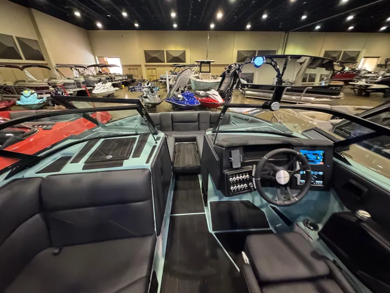 Slide: The Image of 2025 Moomba Max boat interior at a showroom, featuring modern dashboard and seating. - 25