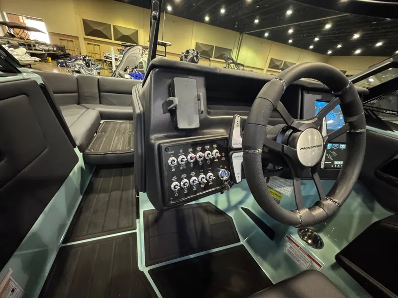 Slide: The Image of 2025 Moomba Max boat interior with steering wheel, control panel, and seating area. - 28