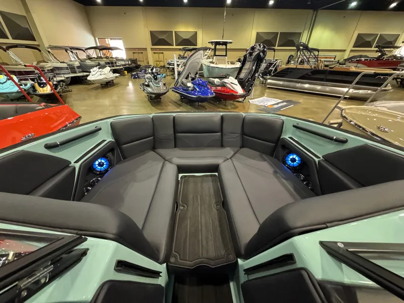 Slide: The Image of 2025 Moomba Max boat interior with spacious seating and modern design in a showroom. - 31